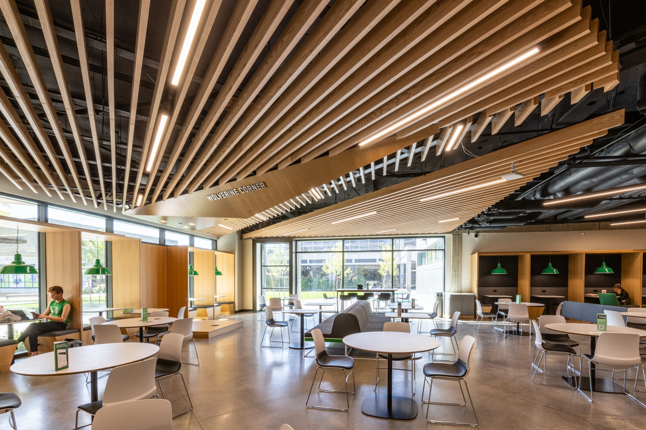 Student commons illuminated beneath a wood slat ceiling