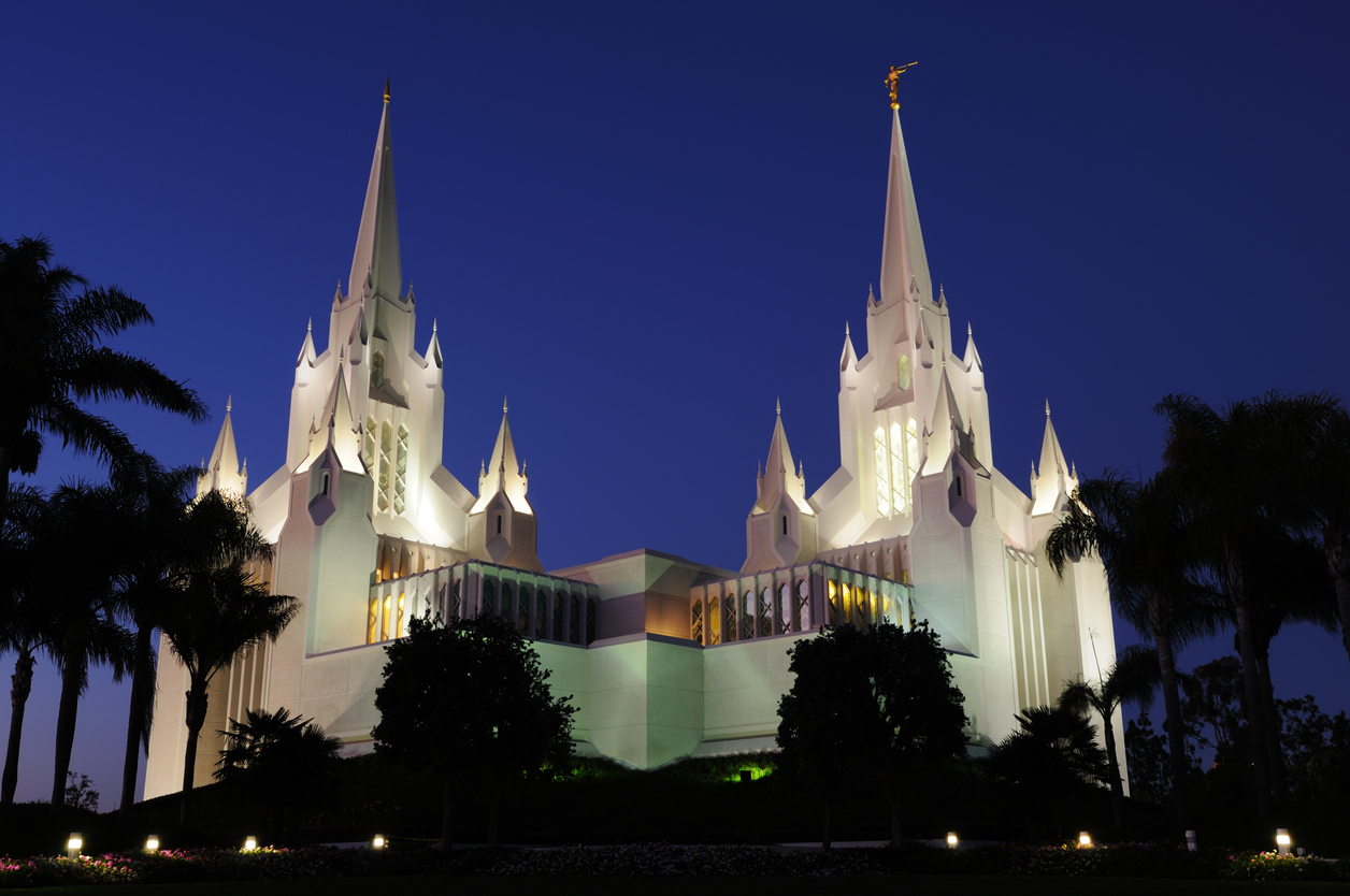San Diego temple illuminated against a dusky sky